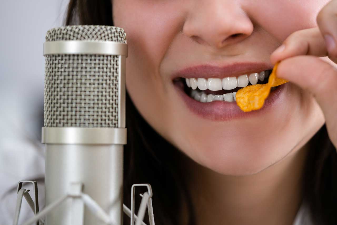 Femme mangeant une chips devant un microphone