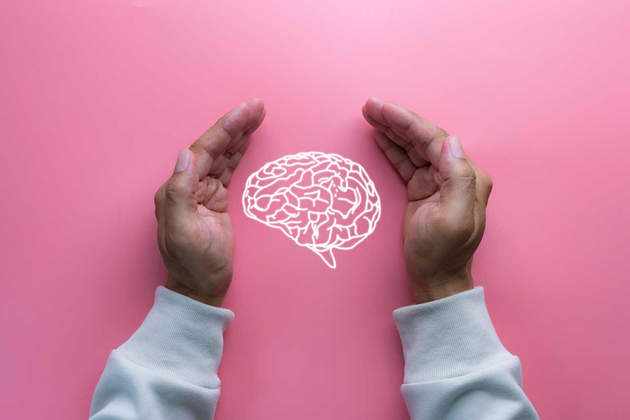 Deux mains entourant un cerveau , symbolisant la protection de la santé mentale