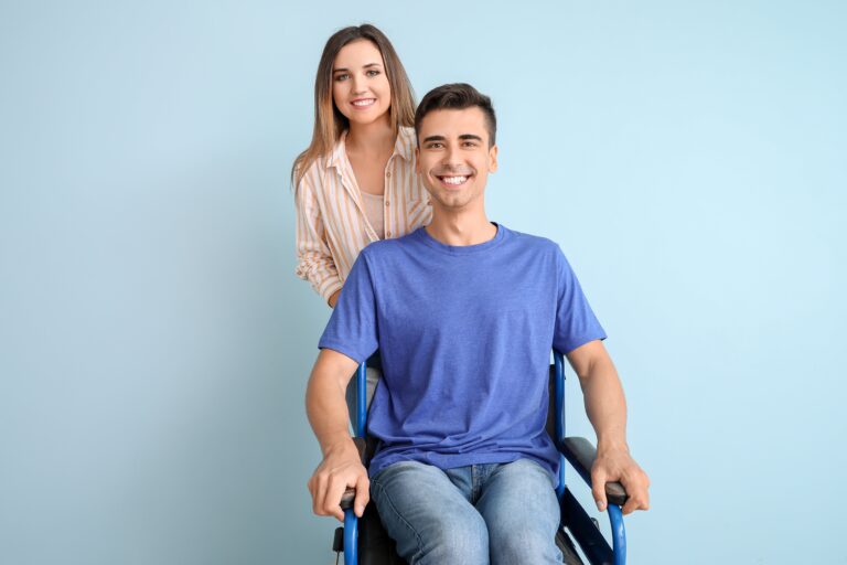 Homme en fauteuil roulant avec une femme debout derrière lui